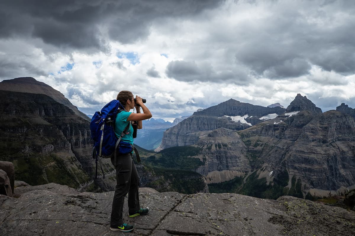 Hiker with a backpack pausing on a high mountain trail