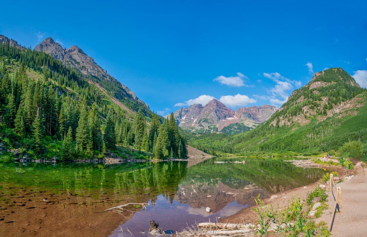 Calm alpine lake mirroring snowy Colorado peaks