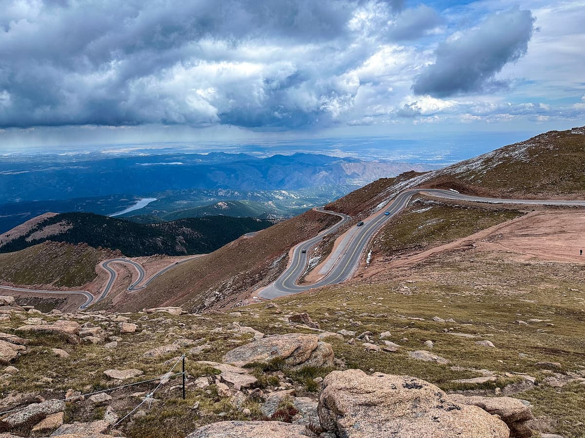 The Devils Playground area, where the Crags route crosses the Pikes Peak Highway, with storm clouds building over the switchbacks