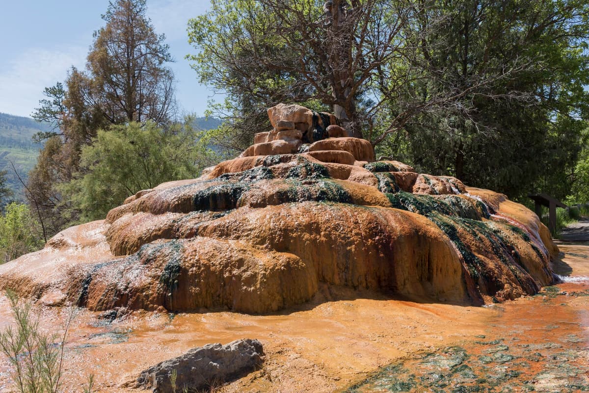 The colorful orange and green travertine mound of Pinkerton Hot Springs beside U.S. Highway 550 north of Durango, Colorado