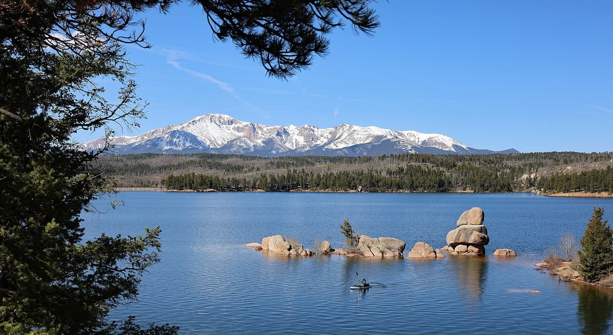 A kayak on the calm water of Rampart Reservoir, a popular fishing and paddling spot near Colorado Springs