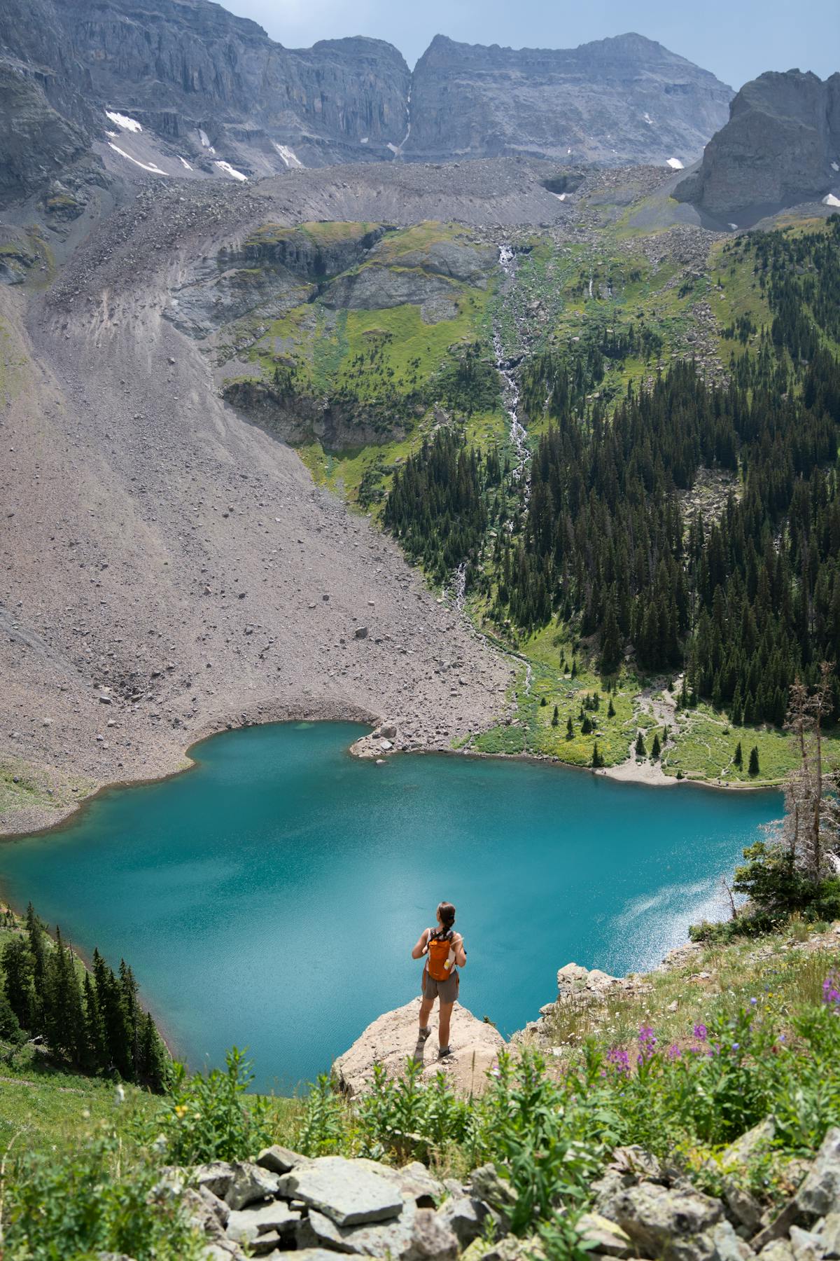 Hiker enjoying a stunning alpine lake view in Colorado mountains